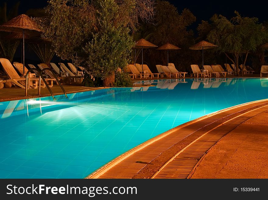 Nightshot of a swimming pool and sun chairs. Nightshot of a swimming pool and sun chairs