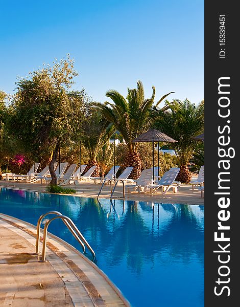 Chaise longues under beach umbrellas near the swimming pool