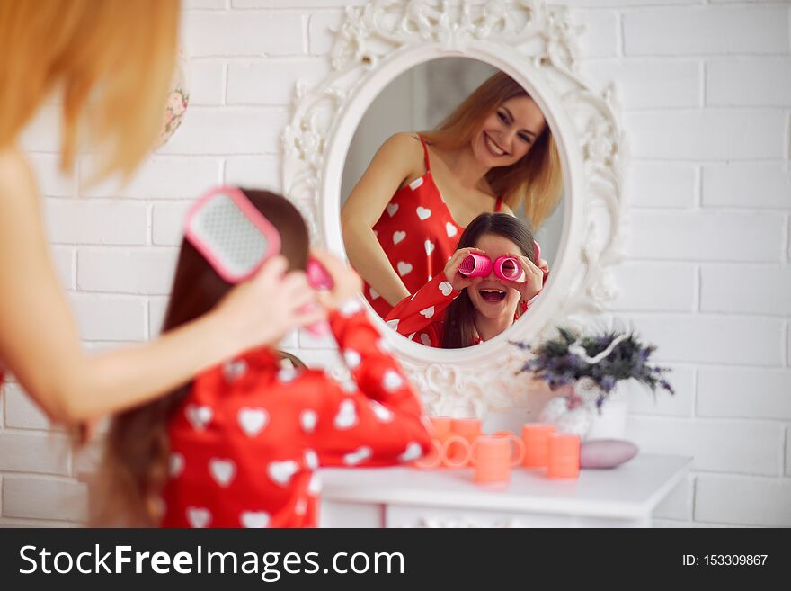 Family at home. Mother with little daughter. Girls in a red pajamas. Family at home. Mother with little daughter. Girls in a red pajamas