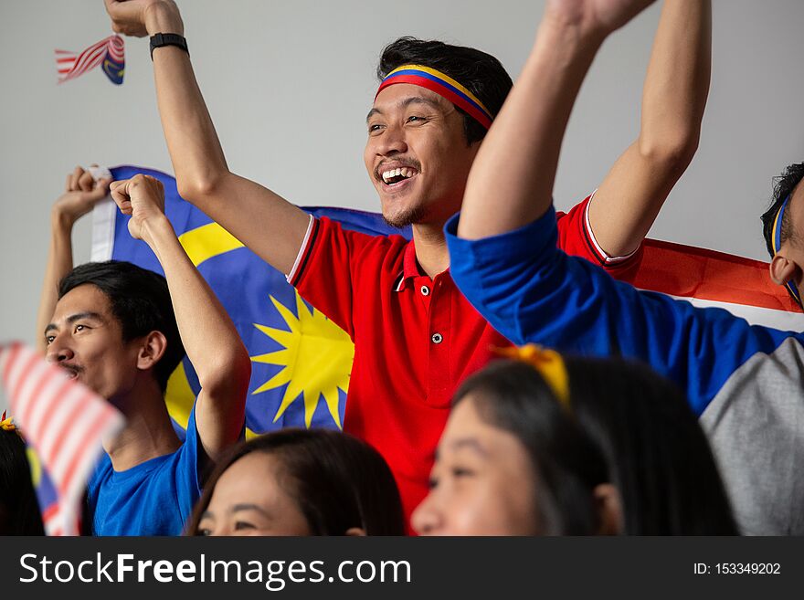 Malay group of people holding malaysia flag celebrating independence day
