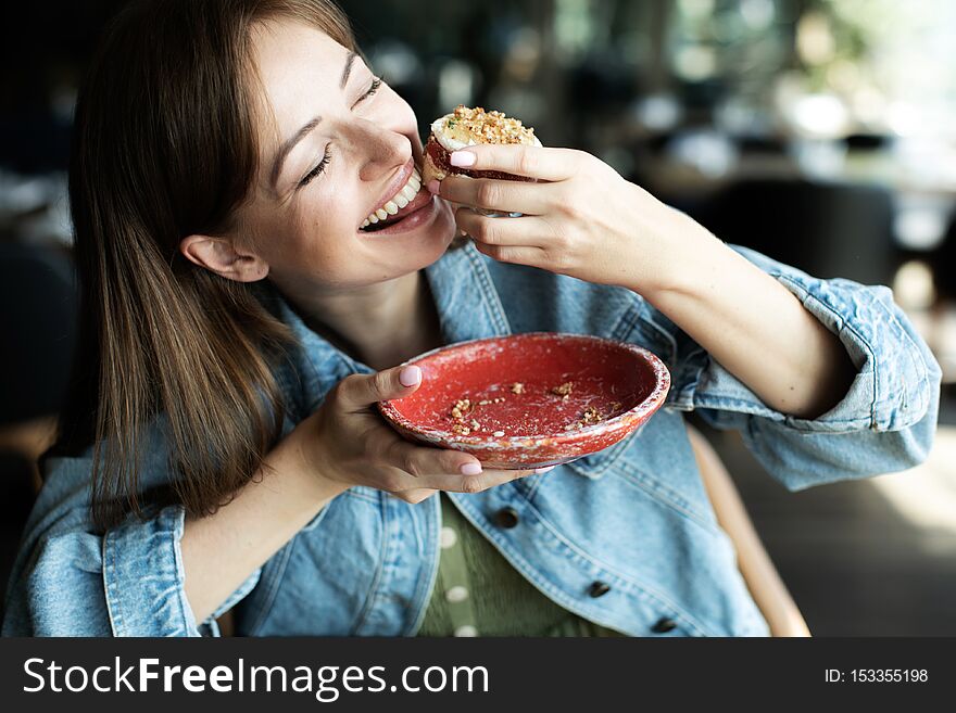 Young girl drinking a tea with dessert in cafe