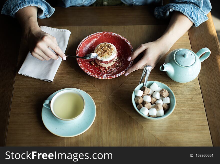 Young girl drinking tea with delicious dessert