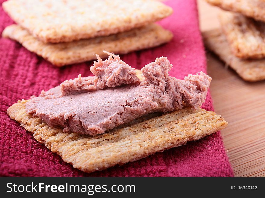 Wheat crackers on a kitchen board with meat paste. Wheat crackers on a kitchen board with meat paste.