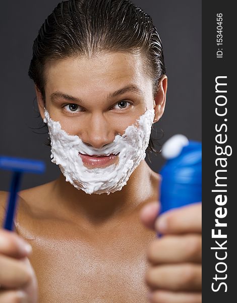 handsome young man shaving. handsome young man shaving