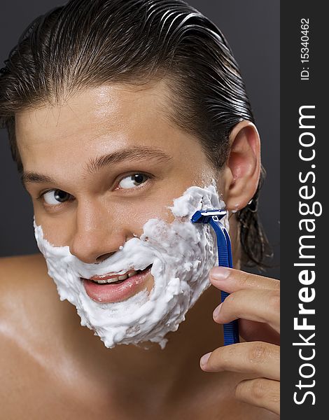 handsome young man shaving. handsome young man shaving