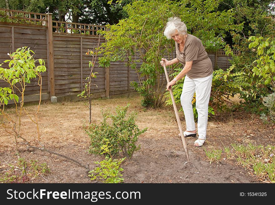 Senior lady gardener doing a little maintenance work. Senior lady gardener doing a little maintenance work