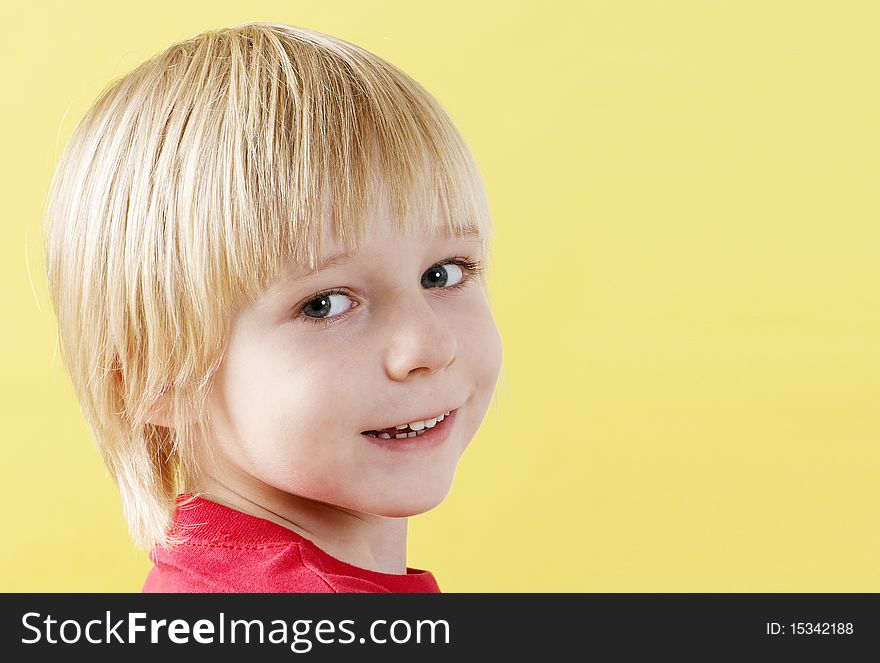 Portrait boy of preschool age on a yellow background