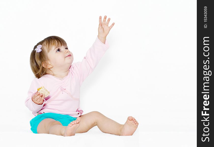 The little girl with the stretched hand on a light background