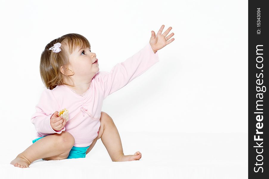 The little girl with the stretched hand on a light background