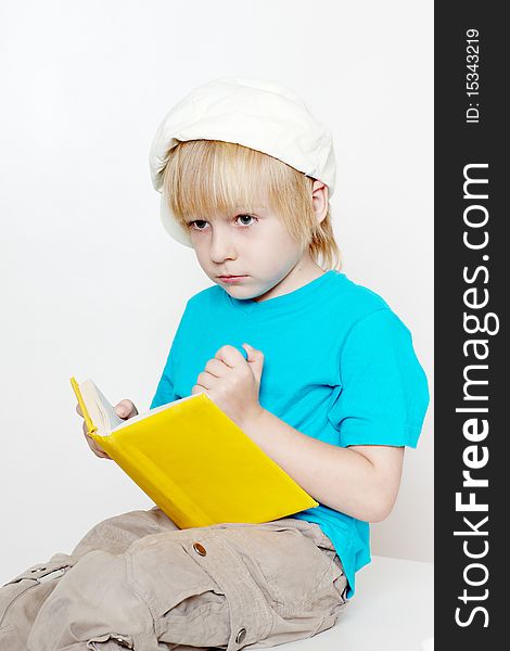 The boy of preschool age with book on a light background