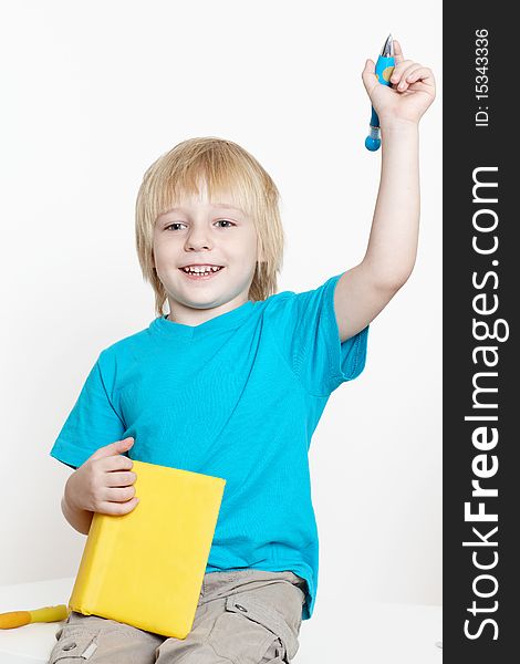 The boy of preschool age with book on a light background
