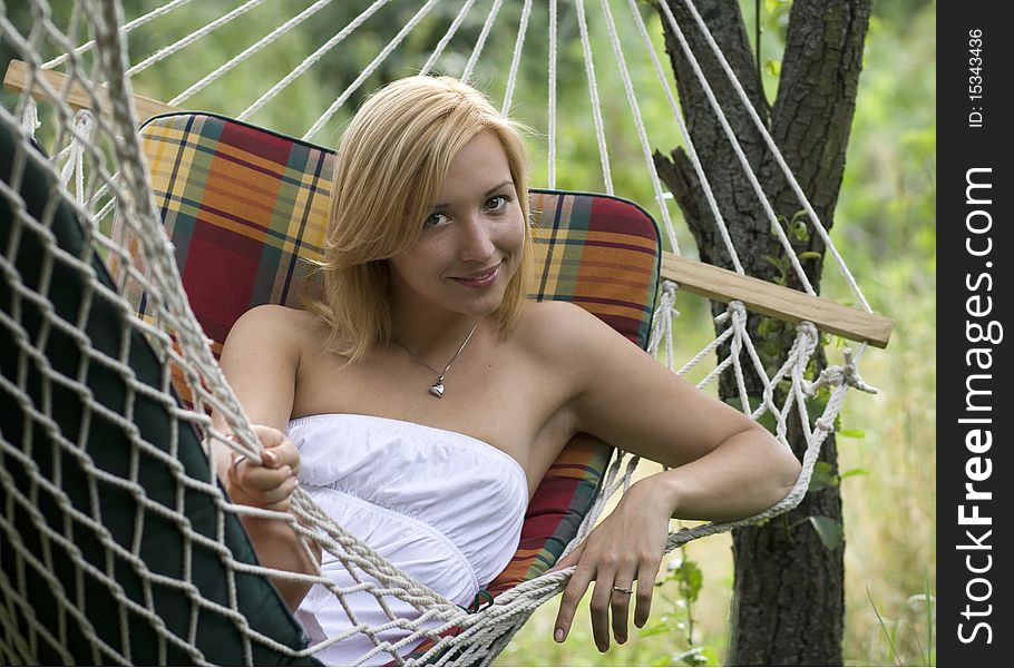 Portrait of a young smiling girl lying in a hammock