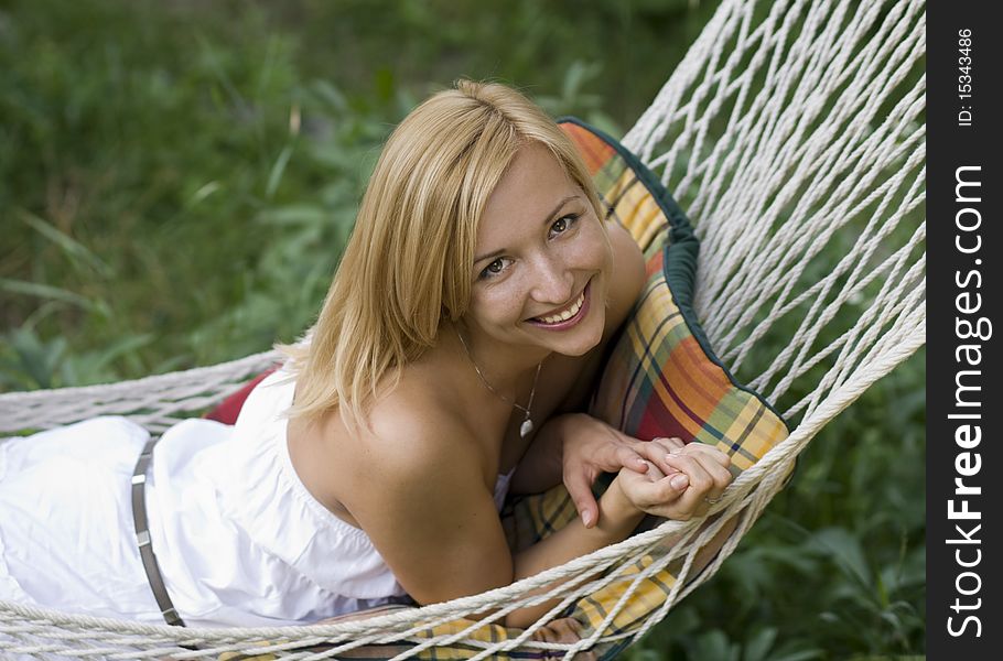 Beautiful young girl smiling while lying in a hammock