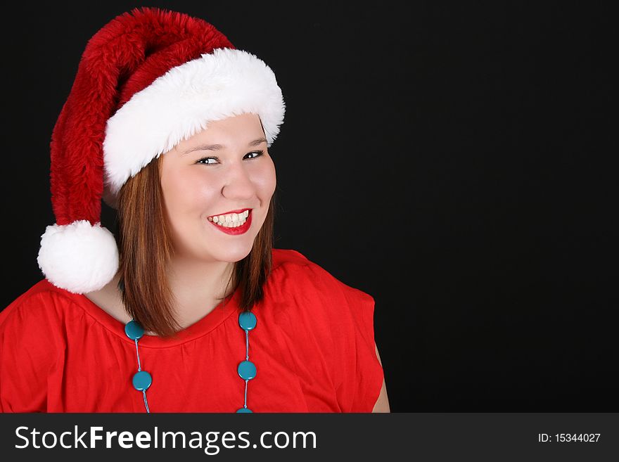 Cheerful young brunette wearing a red top and christmas hat. Cheerful young brunette wearing a red top and christmas hat