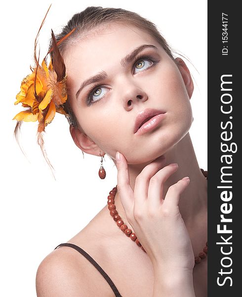 Beautiful girl with an orange flower poses on white background