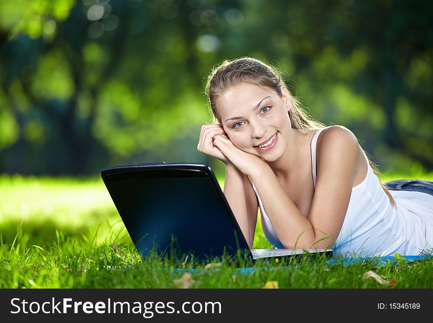 Attractive girl with a laptop in the park