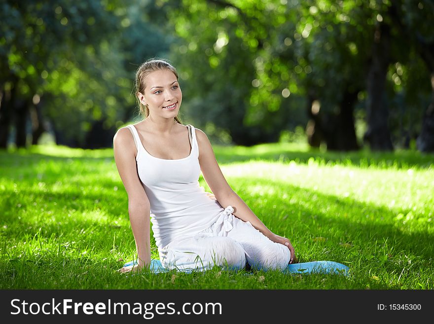 Young attractive girl sitting on the grass. Young attractive girl sitting on the grass