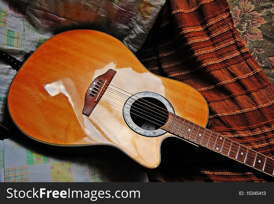 Acoustic guitar against a background of fabric. Acoustic guitar against a background of fabric