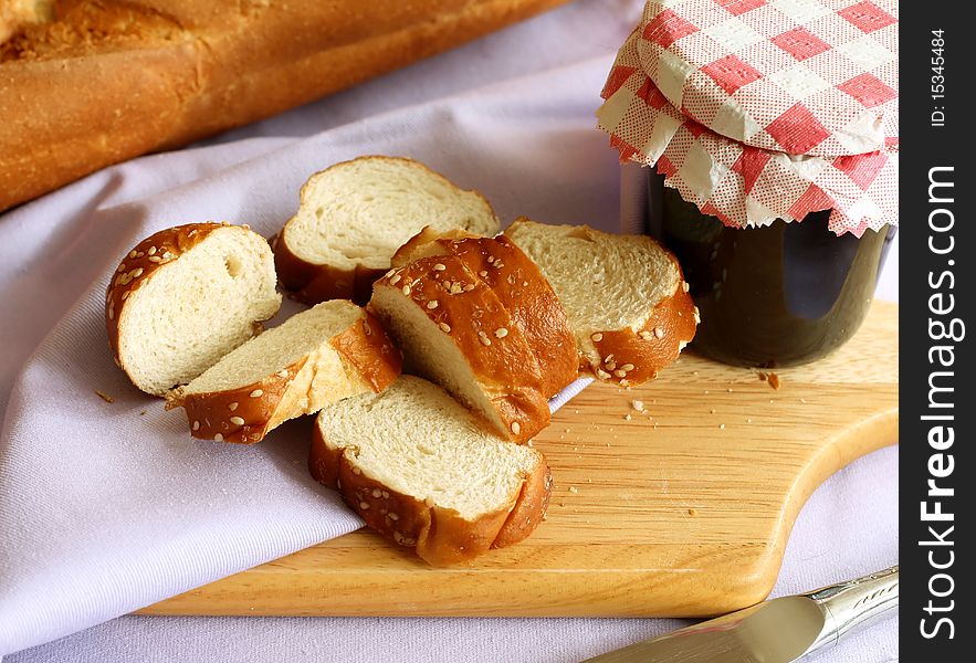 White bread with sesame and glass of jam
