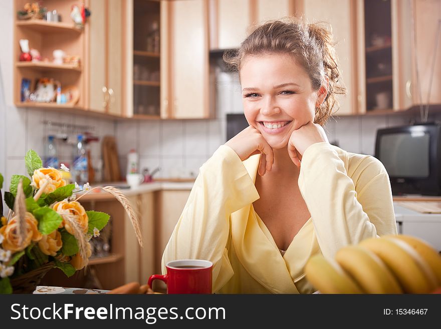 Pretty young adult with beautiful smile having a healthy breakfast in the kitchen. Pretty young adult with beautiful smile having a healthy breakfast in the kitchen