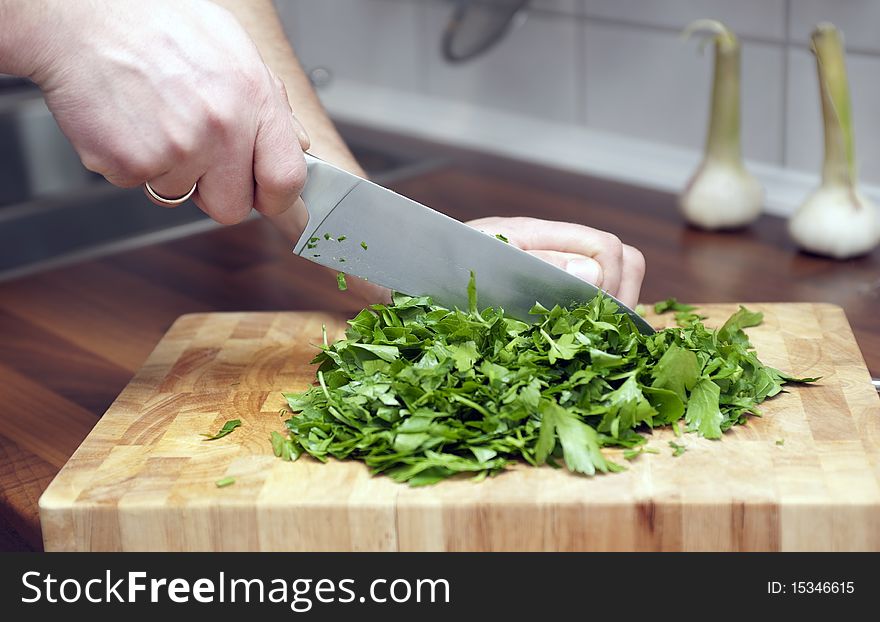 Cook chops fresh parsley with a knife. Cook chops fresh parsley with a knife