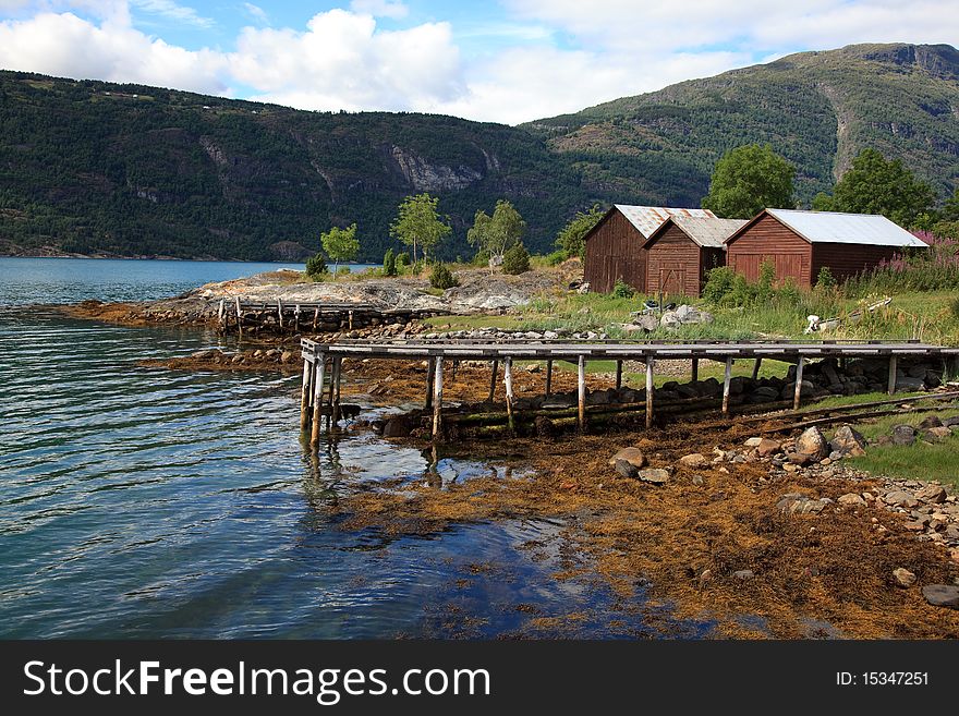Old wooden pier and the boathouses, shot in Norway in Sognefjord. Shot in sunny beautifull day.