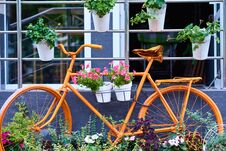 Old Orange Bicycle Decorated With A Flowers. Cafe Decore In City Stock Photos