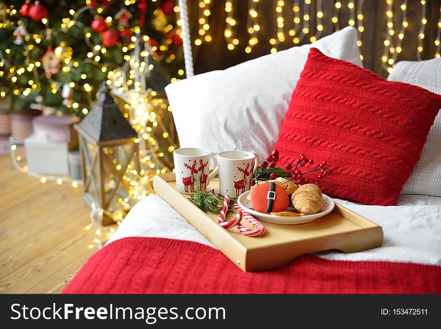 Breakfast in bed, tray with cup of coffee and croissant. Modern bedroom interior. Romantic morning surprise. Christmas mood