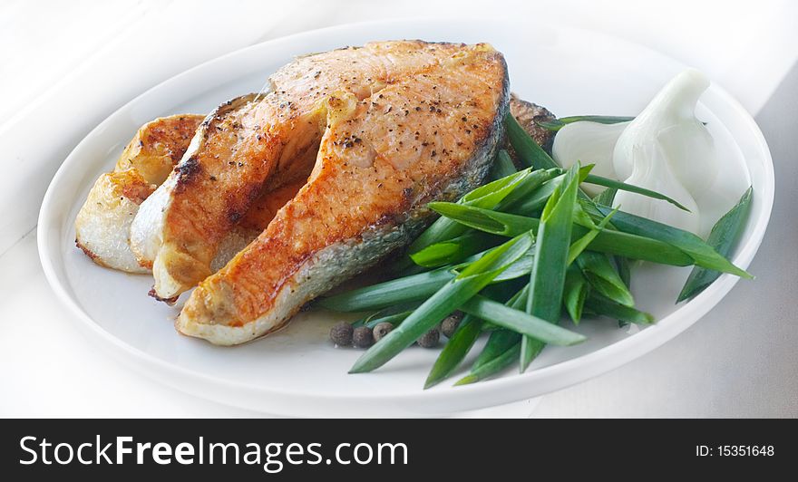 Salmon steak meal on a white plate