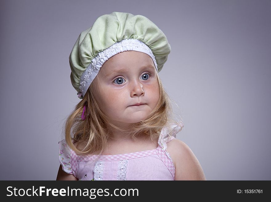 Cute girl with big blue eyes and funny green hat. Cute girl with big blue eyes and funny green hat