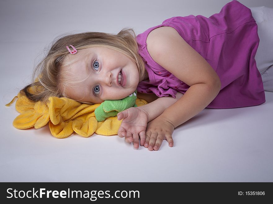 Cute little blonde girl on a yellow pillow. Cute little blonde girl on a yellow pillow
