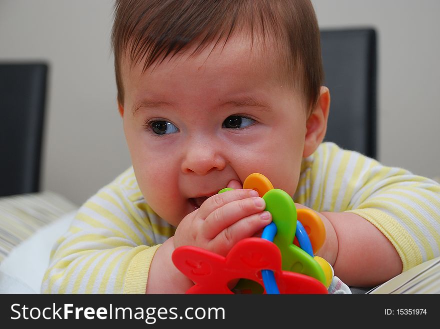 Laying Small Baby With A Toy