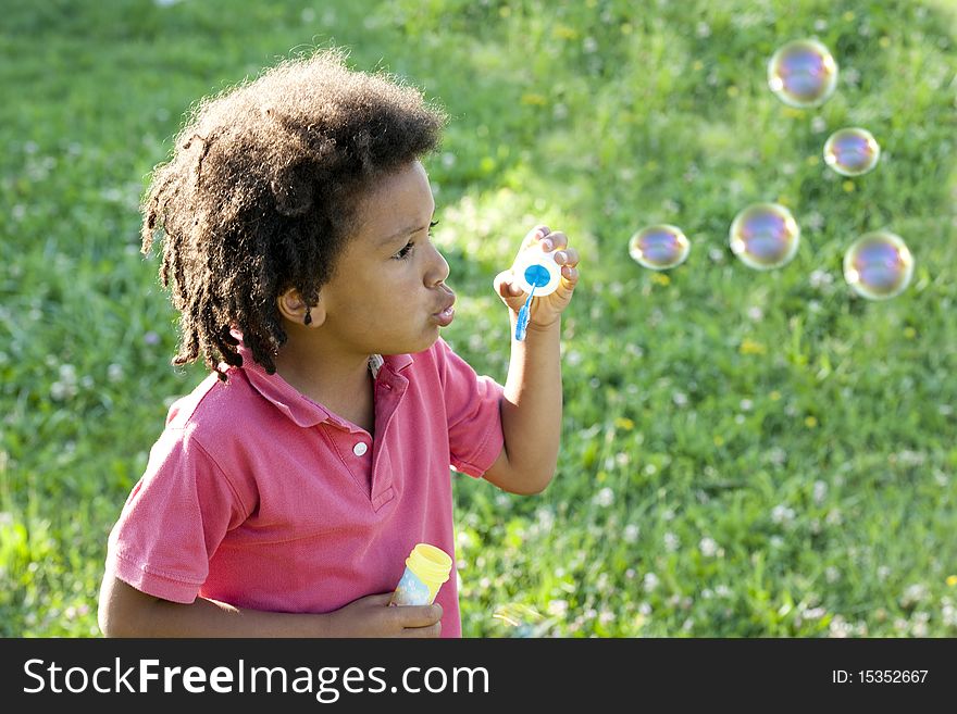 Cute little boy making soap bubbles