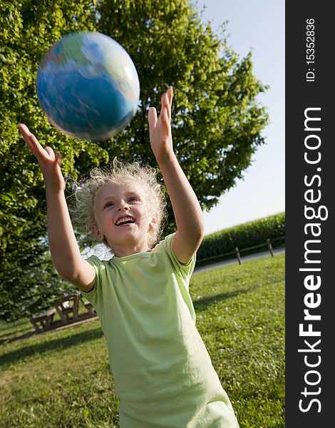 Little girl receiving the globe. Concept: earth in children hands