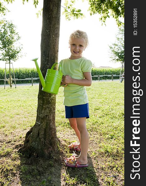 Little girl watering tree. Concept: taking care of nature
