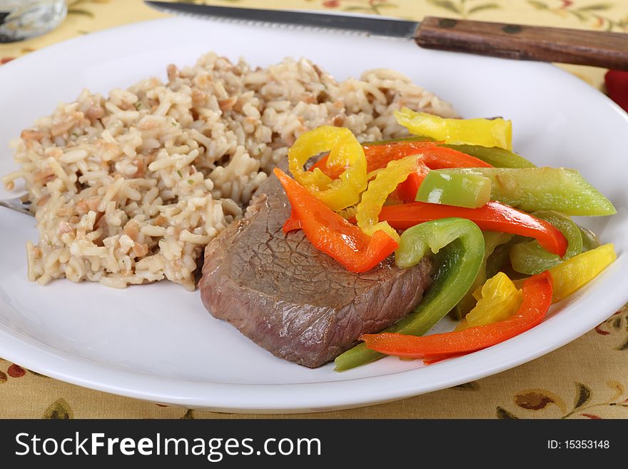 Beef sirloin steak covered with red and green peppers with rice. Beef sirloin steak covered with red and green peppers with rice