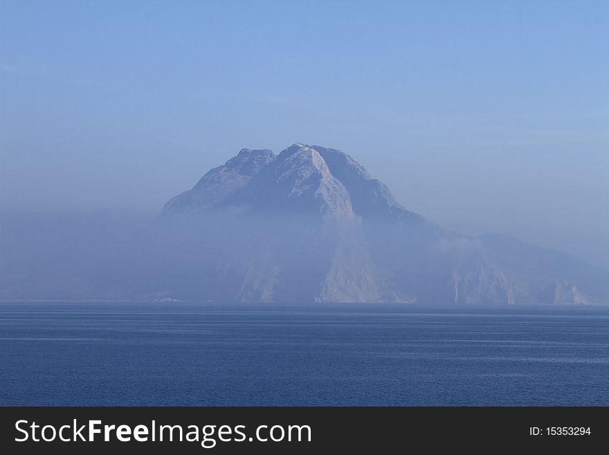 Mountain surrounded by cloud with water foreground. Mountain surrounded by cloud with water foreground