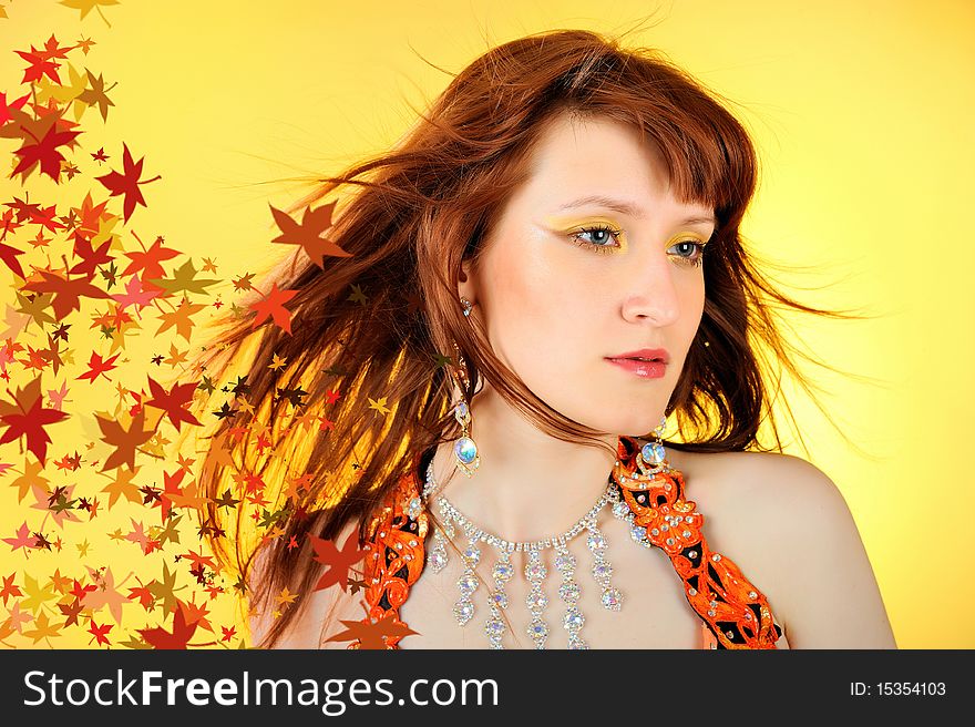 Beautiful autumn fairy woman with golden make-up and hair of falling leaves. Beautiful autumn fairy woman with golden make-up and hair of falling leaves.