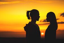 Waist Silhouettes Of A Young Millenial Couple In Love With A Man And A Girl Look At Each Other. Two Profile Of A Young Stock Image