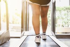 Close Up Shoes Woman Running On Treadmill. Woman With Muscular Legs In Gym Royalty Free Stock Photography