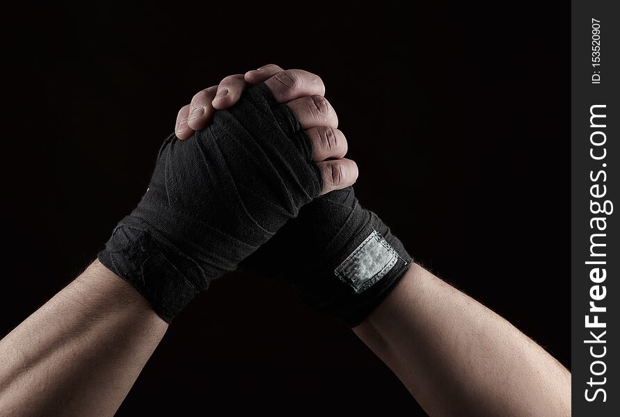 gesture of friendship, two male hands of an athlete tied with a black textile bandage