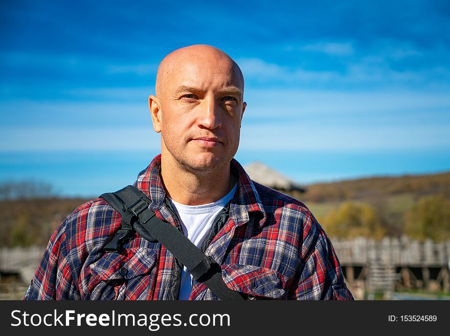 Portrait of a bald man against the sky and mountains