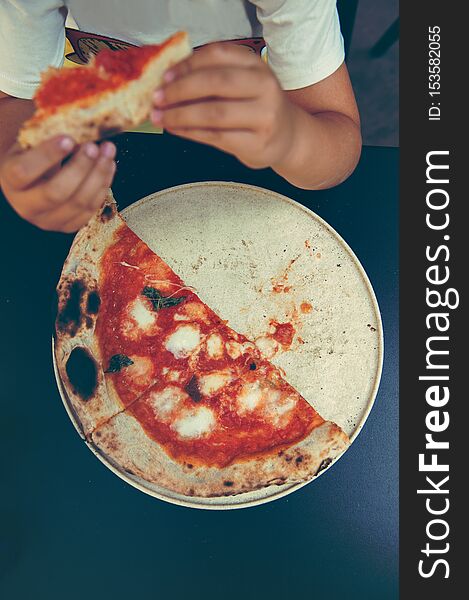 High angle shot of unrecognizable people`s hand grabbing a slice of pizza margherita