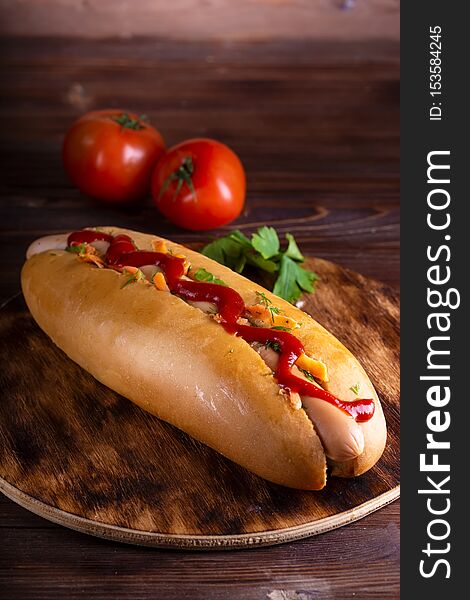 Homemade food Hotdog stuffed with sausage and vegetables in wooden plate on wooden table Close up