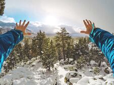 Male Hands Stretching Toward The Beautiful Snowy Forest With South Lake Tahoe In The Background Royalty Free Stock Images