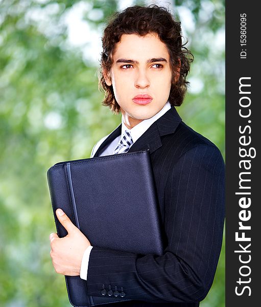 Portrait of a young businessman with folder in hand