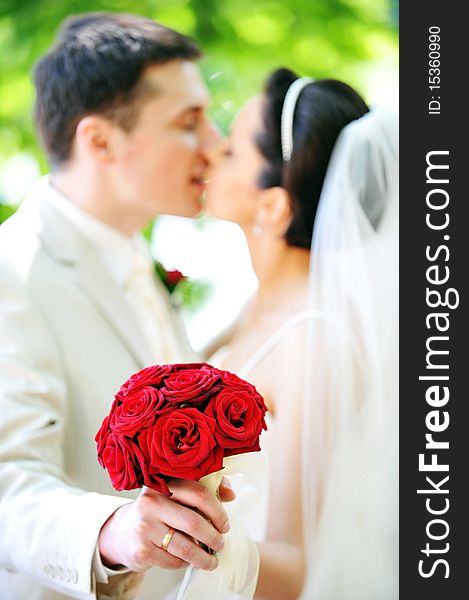 Groom and bride in white dress on background of green trees. Groom and bride in white dress on background of green trees