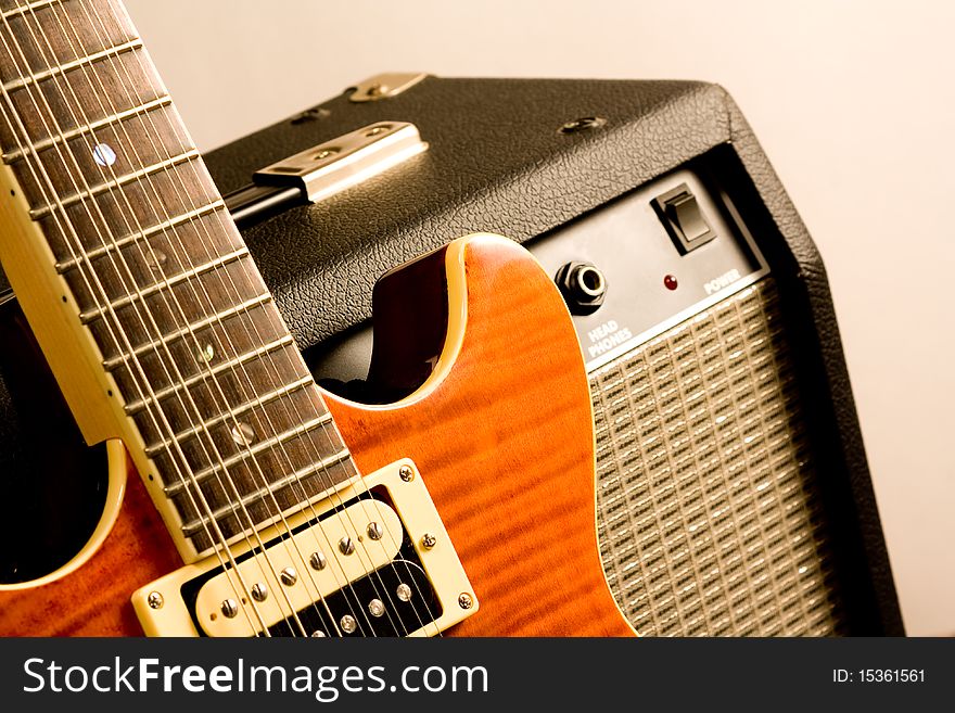 12 string electric orange guitar resting against black amplifier. 12 string electric orange guitar resting against black amplifier