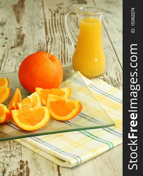 Fresh oranges and orange juice in glass on wooden boards