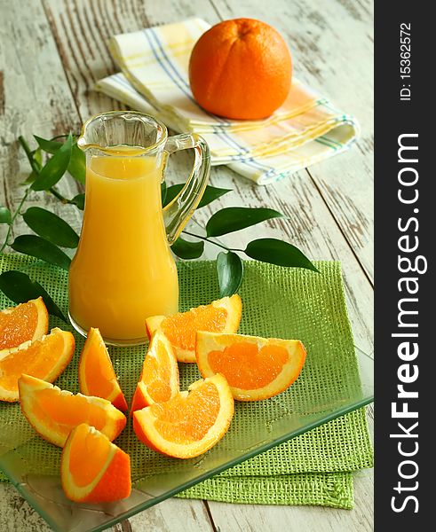 Fresh oranges and orange juice in glass on wooden boards